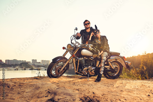 Sexy couple of bikers on the vintage custom motorcycle, girl in a rabbit mask