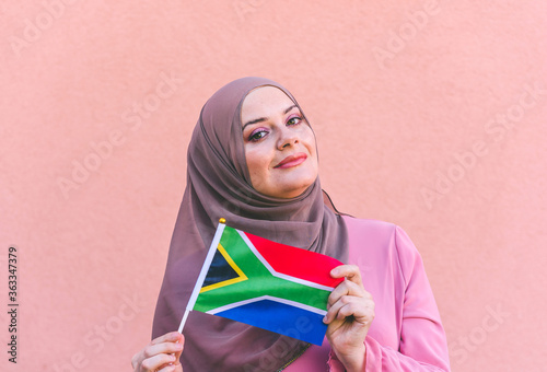 Photography Muslim woman in hijab holds flag of South Africa