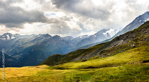 beautiful panorama with painty green grass, high mountains and clouds in the austrian alps in the Grossglockner area 