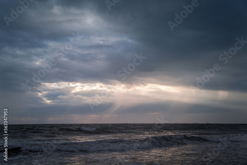 Beautiful evening sky with sun rays shining through the clouds over the Arabian Sea
