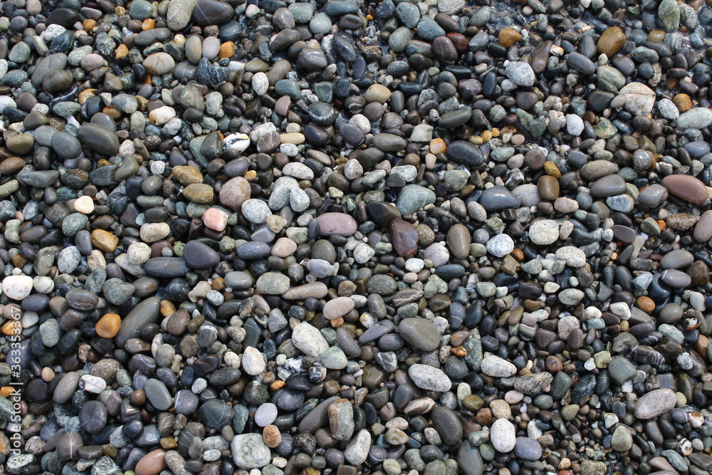 Grey black white brown pebbles stones on the beach background Grey black white brown pebbles stones on the beach background