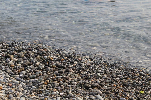 Pebbles on the stone beach with sea water