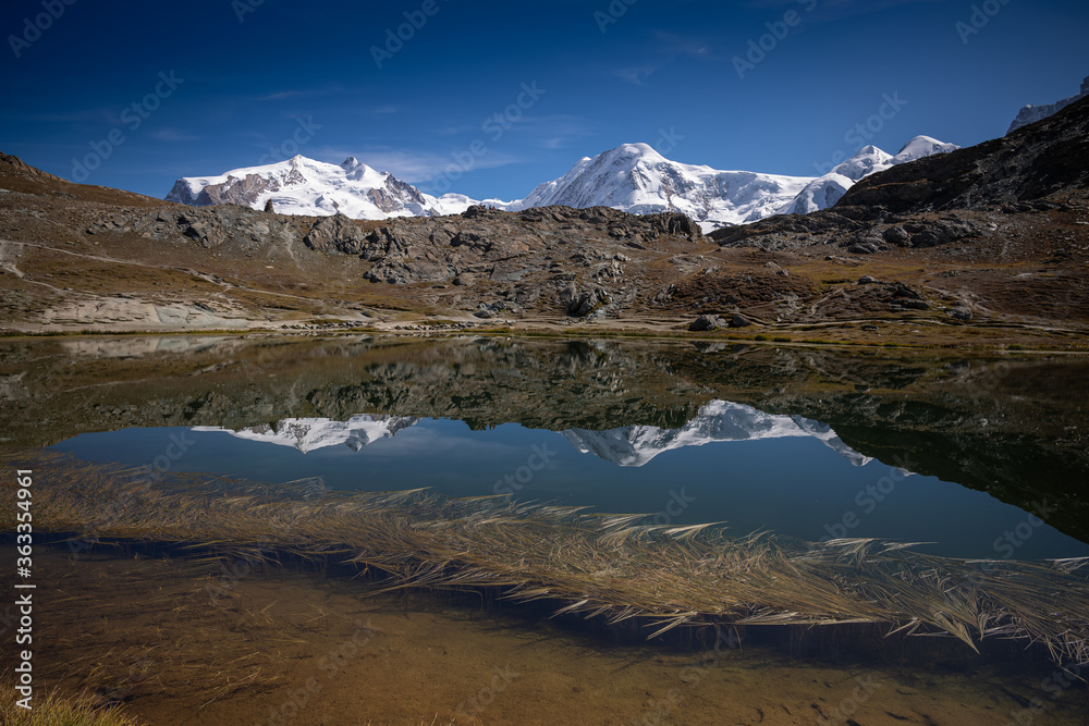 Alpine lake & the Monte Rosa massif, flanked by glaciers, is the highest mountain in the Swiss Alps. 