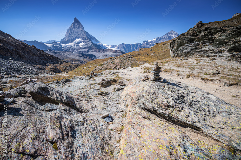 Rocky Mountain trail in the Swiss Alps matterhorn in background on a sunny day