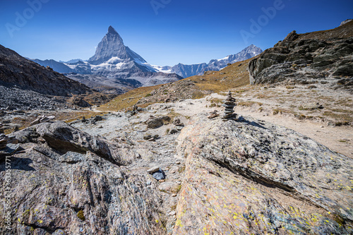 Rocky Mountain trail in the Swiss Alps matterhorn in background on a sunny day