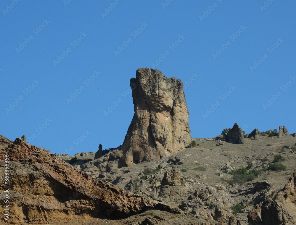 A rock against a bright blue sky.