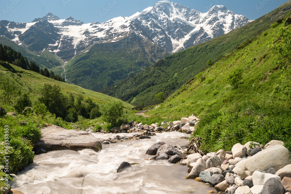 Fototapeta premium Turquoise water in mountain river on valley and glacier on background.