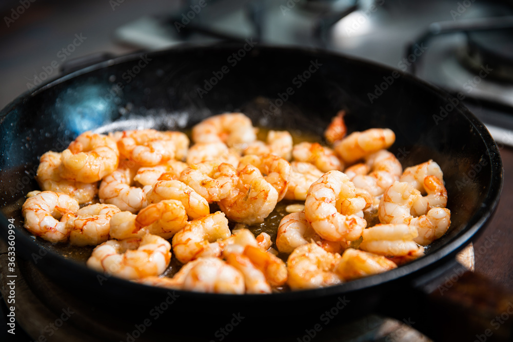 Process of frying giant red shrimps with garlic on olive oil on pan. Process of frying giant red shrimps with garlic on olive oil on pan.