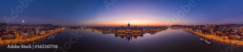 Panoramic aerial drone shot of Hungarian Parliament lights off sunrise in Budapest dawn