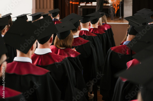 Group of fresh university graduates with robes and caps in ceremony