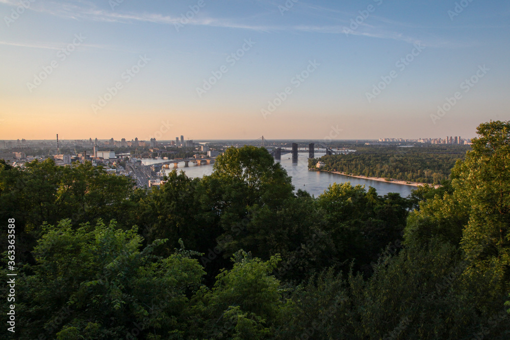 The sun sets on the Dnieper River and Kiev, Ukraine on a beautiful summer evening.