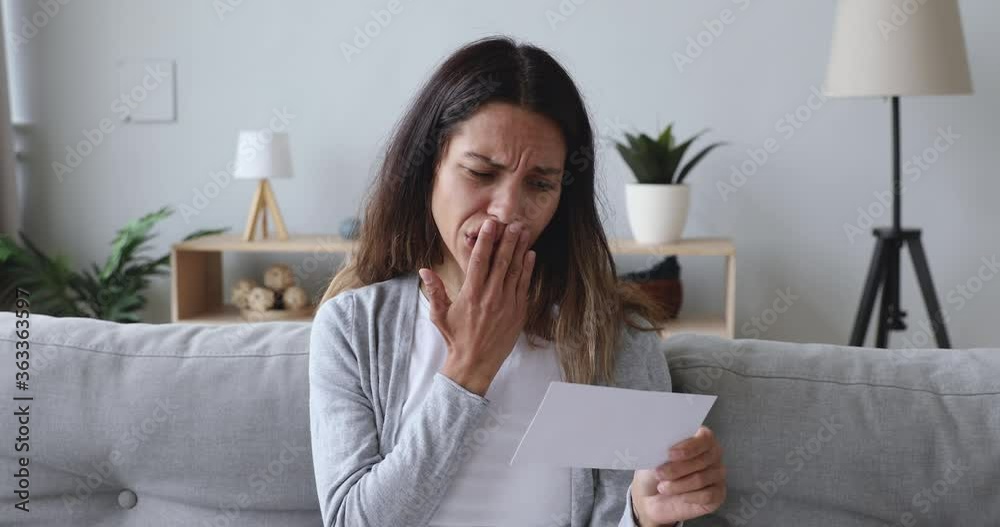 Desperate stressed young woman tearing photo with ex boyfriend after breakup divorce feeling jealous frustrated heartbroken ripping couple picture suffer from heartbreak sit on sofa at home alone