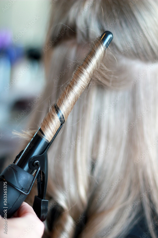 Obraz premium Kręcenie włosów lokówką