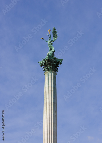 The statue of Archangel Gabriel on top of the Heroes Square Column against a cloudy sky in Budapest  Hungary.