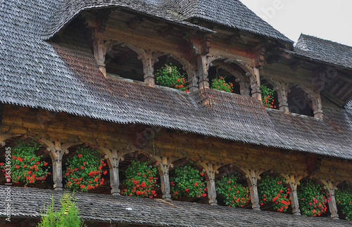 Obraz na płótnie Barsana Monastery, Maramures, Romania, Europe, Summer 2018. Wooden building with red geraniums hanging from the windows of the Barsana Orthodox Monastery. w salonie