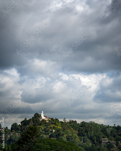 clouds over the mountain. white buddha at the top of the mountain. Kandy  Sri Lanka