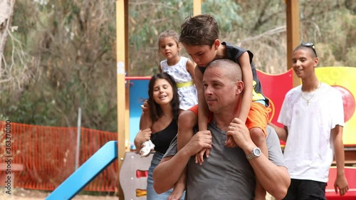 Video in 4k di una famiglia mista tra Italiani e brasiliani che si muove in un parco photo