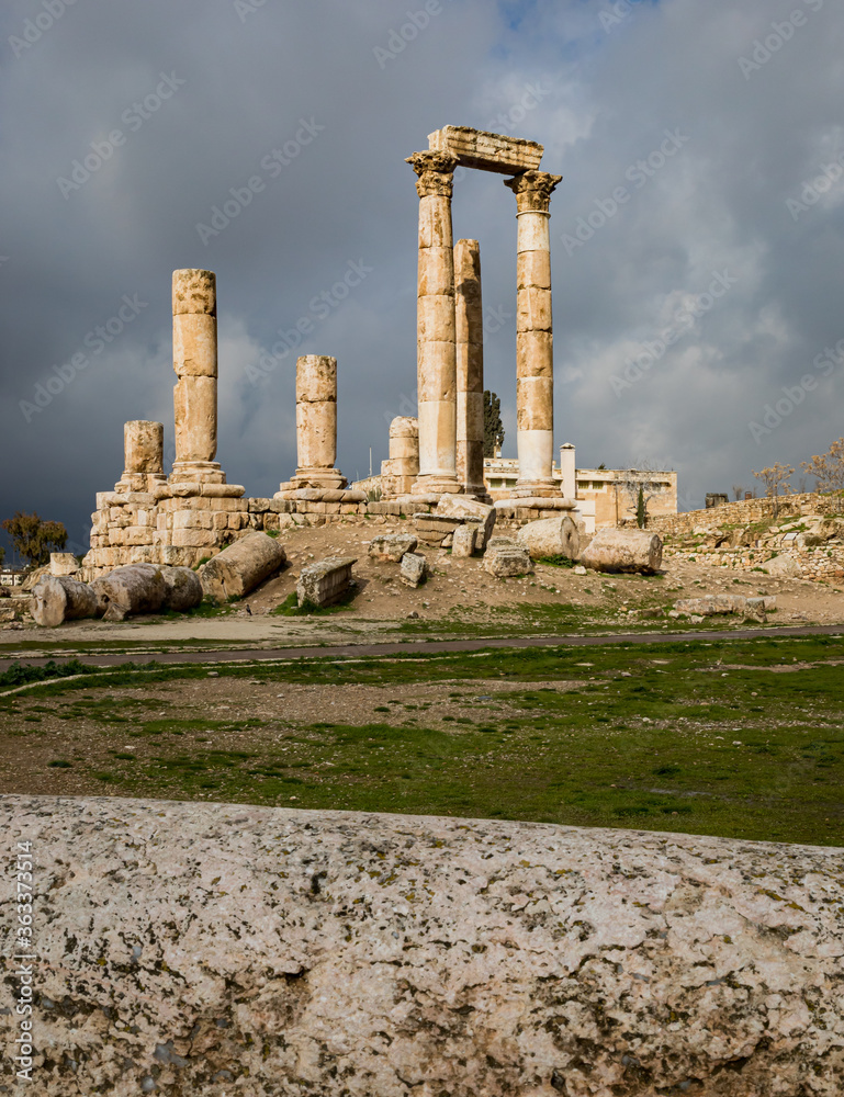 View of the ruins of the temple of Hercules on the top of the mountain of the Amman citadel against the background of a dramatic sky with clouds