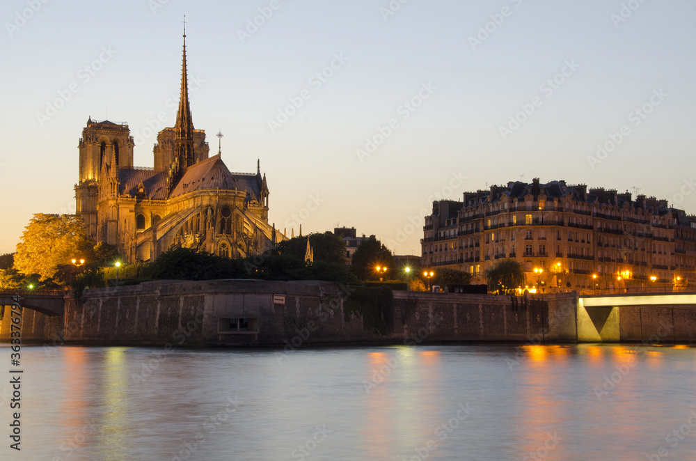 Notre Dame cathedral and seine river at dusk in Paris, France.