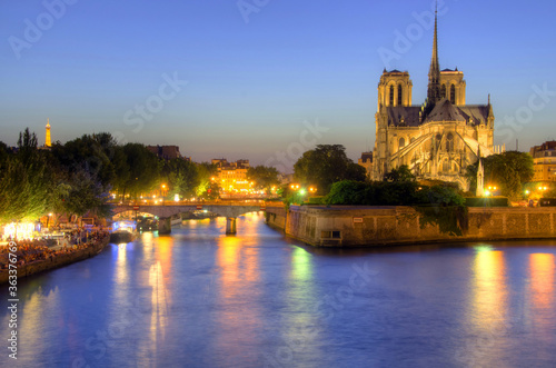 Notre Dame cathedral and seine river at dusk in Paris, France.