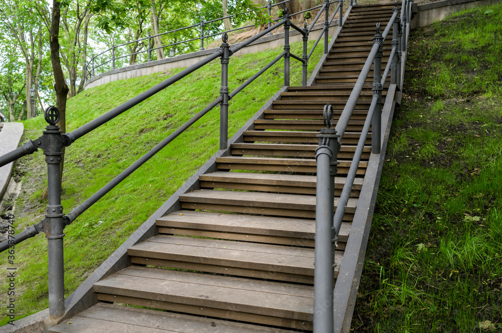 wooden steps with metal railing in a pedestrian park