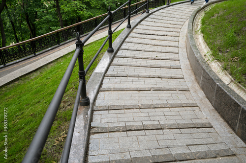 Fototapeta Naklejka Na Ścianę i Meble -  landscaped stone steps in a pedestrian park with metal railings