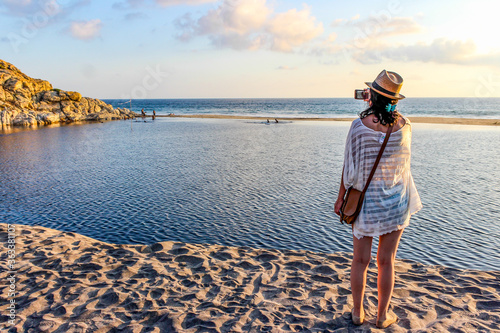 Girl taking picture with her phone to a lagoon that converges with the beaches of Oaxaca. photo