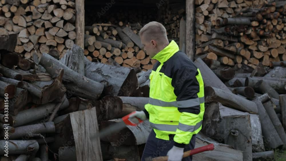 Lumberjack in reflective jacket. Man woodcutter holds small axe and saw on his hands. Firewood Lumberjack in reflective jacket. Man woodcutter holds small axe and saw on his hands. Firewood
