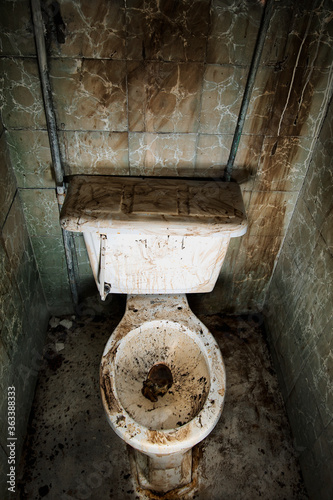 A very dirty abandoned toilet in a bathroom