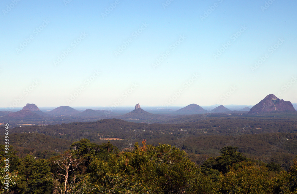 Glass House Mountains, Sunshine Coast, Queensland, Australia showing blue sky, mountains, paddocks, farming land and forests