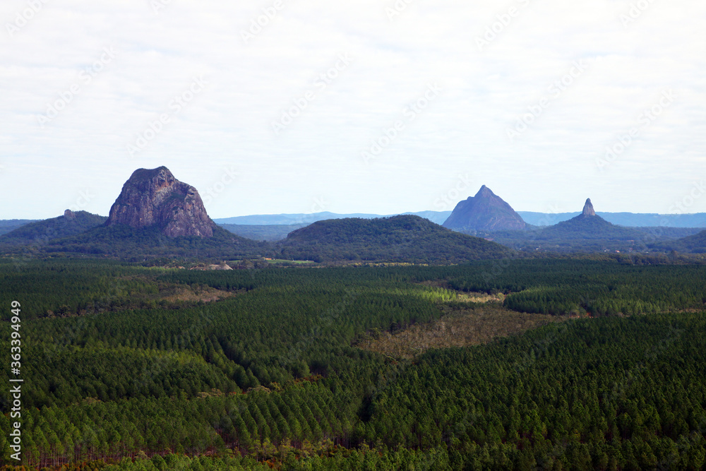 Glass House Mountains, Sunshine Coast, Queensland, Australia showing blue sky, mountains, paddocks, farming land and forests