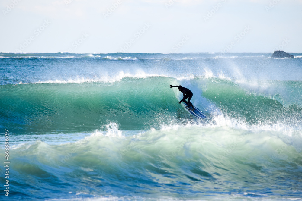 Surfer on Blue Ocean Wave riding on surfing board in Asia. Japan is famous for its great waves near to Tokyo City Surfer on Blue Ocean Wave riding on surfing board in Asia. Japan is famous for its great waves near to Tokyo City
