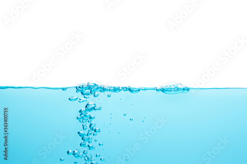 The bubbles in the water float in the middle of the water up to the surface in a straight line. Blue background