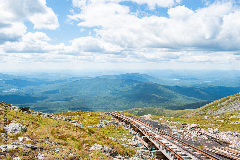 Railroad tracks in the mountains under vivid blue summer skies.