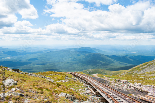 Railroad tracks in the mountains under vivid blue summer skies.