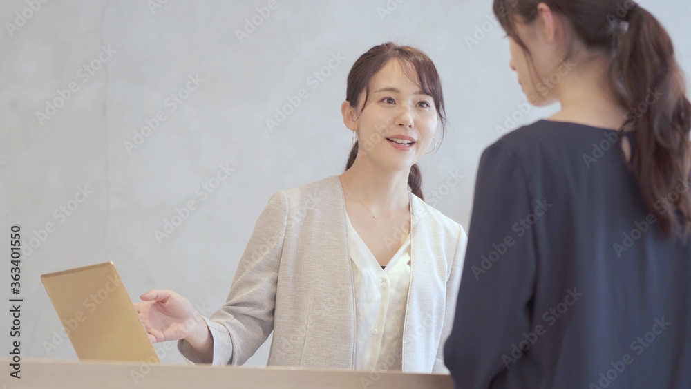 カウンターで接客をする女性 カウンターで接客をする女性