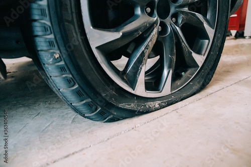 a flat tire on an automobile in a car garage with copy space
