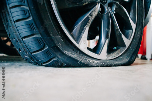 a flat tire on an automobile in a car garage with copy space