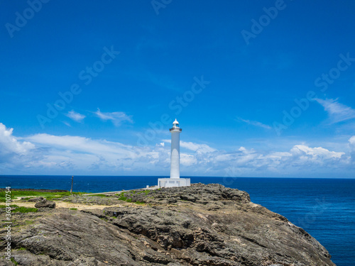 夏のさわやかな青空と沖縄の観光スポットの残波岬灯台と海と崖 01