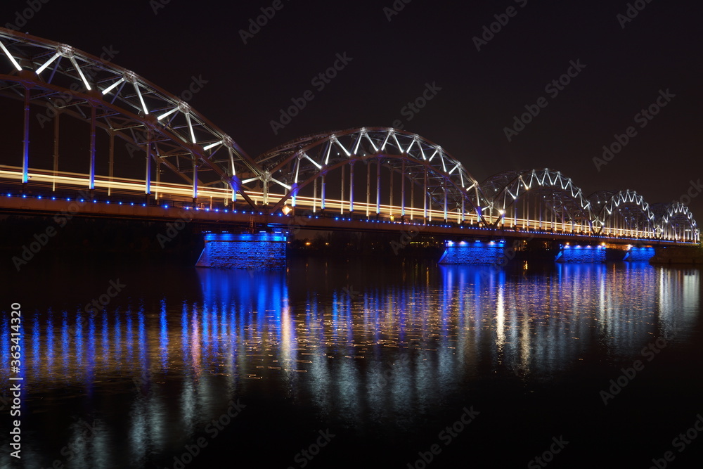 Glittering night scene of the Railway Bridge Daugava River in Riga Latvia. Photo for art decoration and blog story.