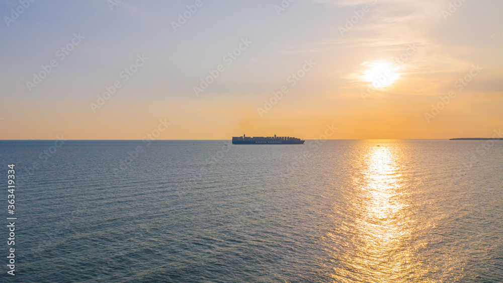 During sunset a Container cargo ship arriving in the harbor. During sunset a Container cargo ship arriving in the harbor.