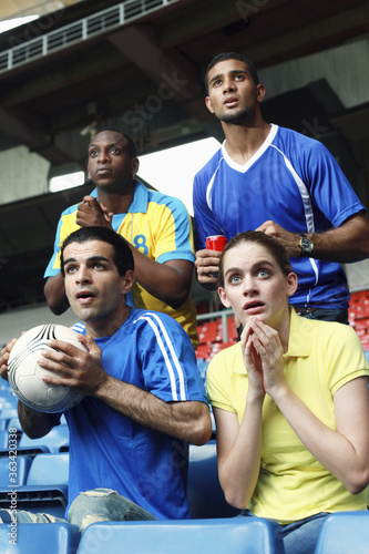 Men and woman watching soccer match in stadium
