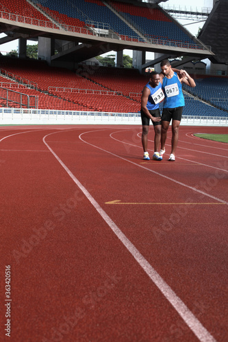 Male athlete helping another injured athlete