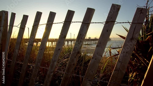 Timelapse Slider Shot of Bogue Inlet Fishing Pier Seen Through a Fence at Sunrise - Emerald Isle, North Carolina  photo