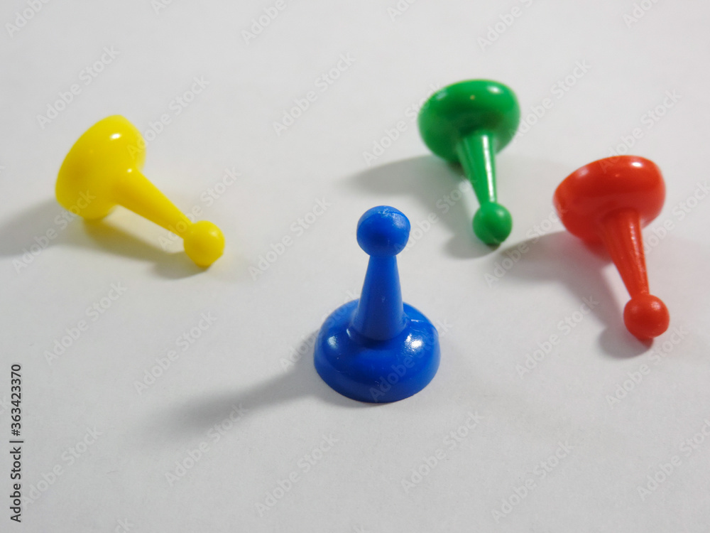 colorful plastic game pieces on white background colorful plastic game pieces on white background