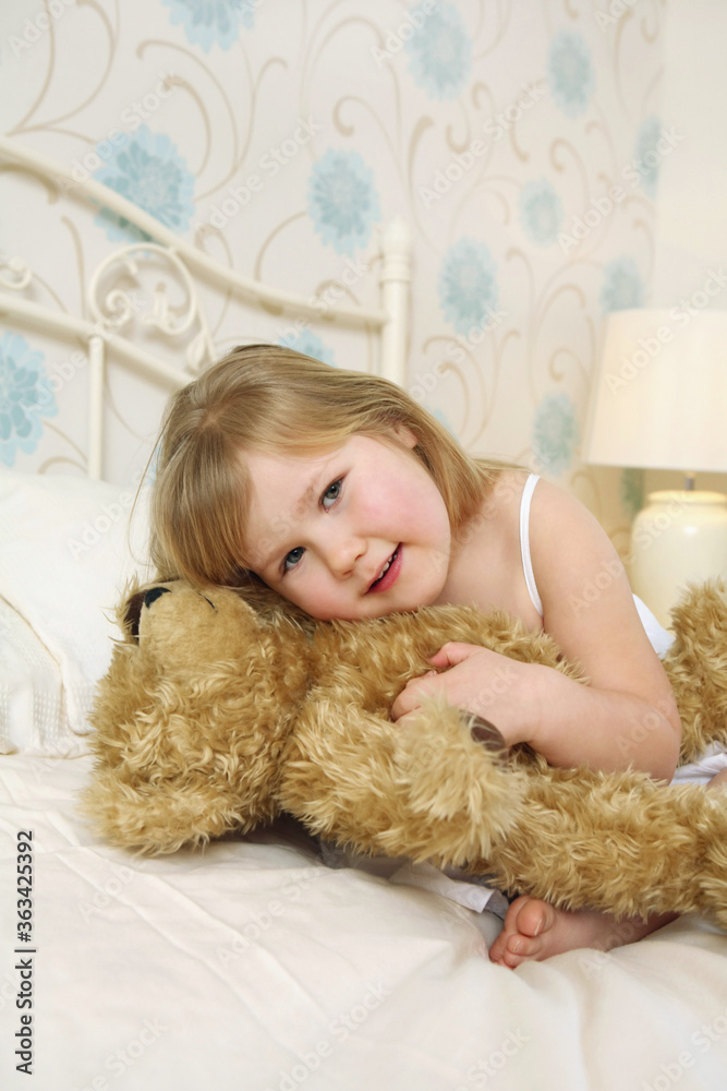 Girl hugging teddy bear on bed Girl hugging teddy bear on bed