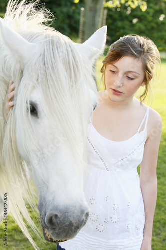 Girl petting horse outdoors