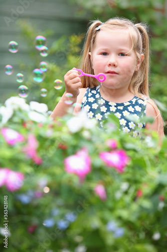 Girl blowing bubbles in the garden