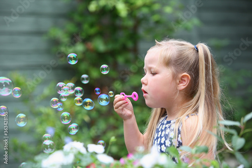 Girl blowing bubbles in the garden