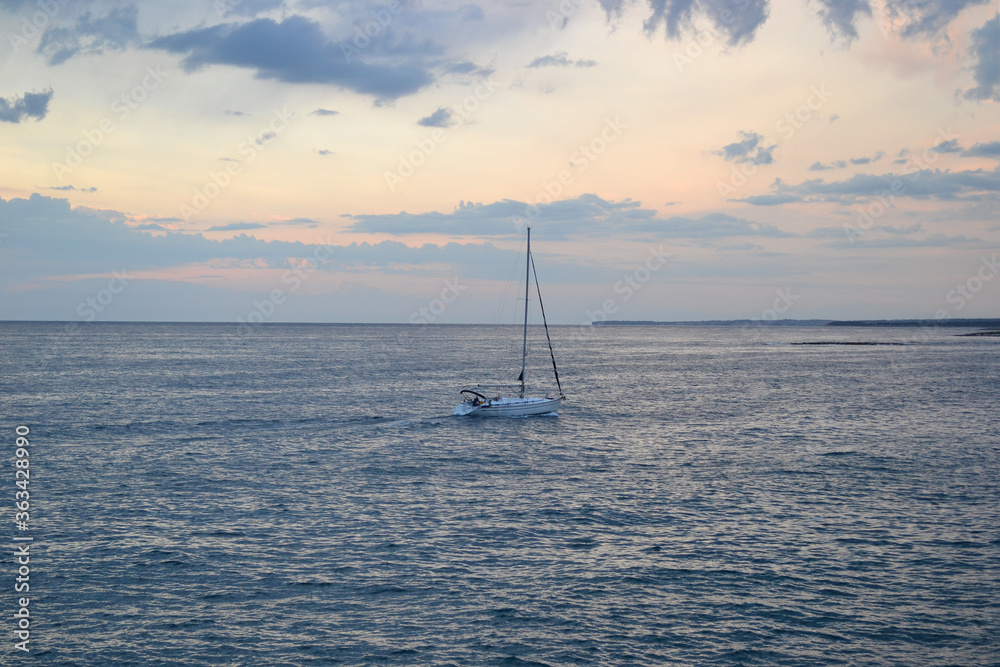 sailboat in the sea at sunset